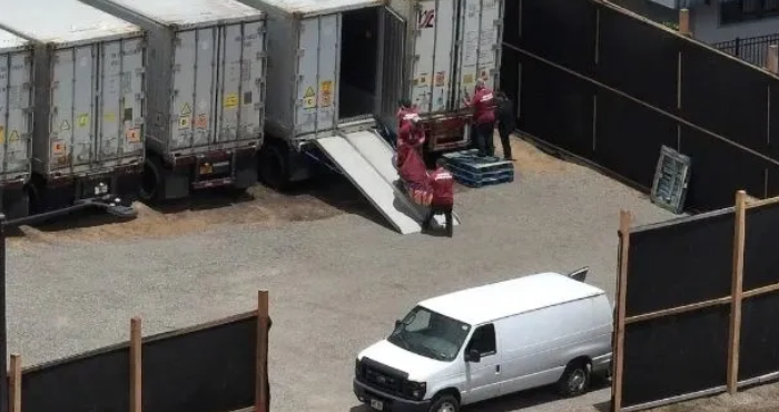 A white truck and two men loading boxes.